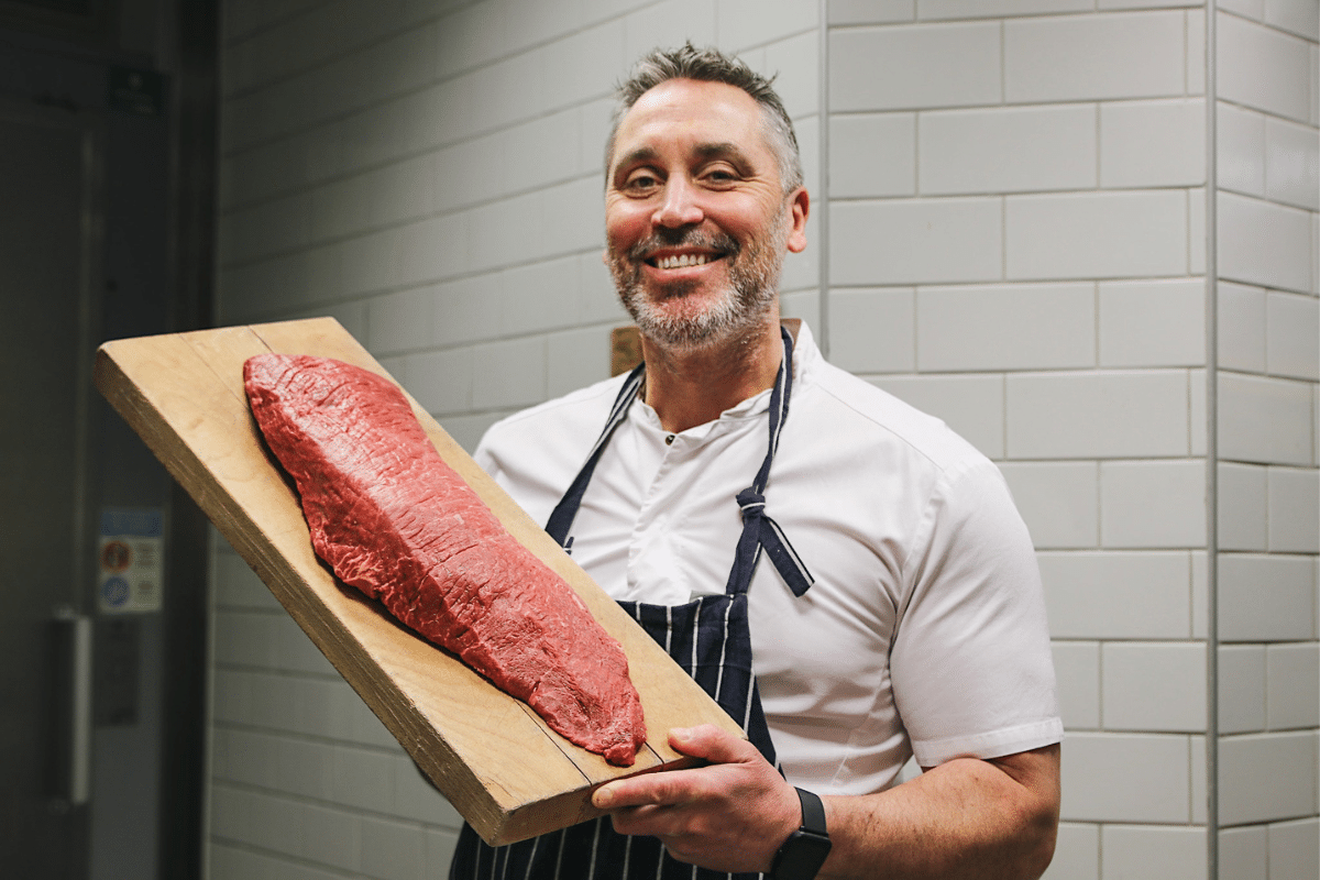 man som håller upp kött som ska bli råbiff